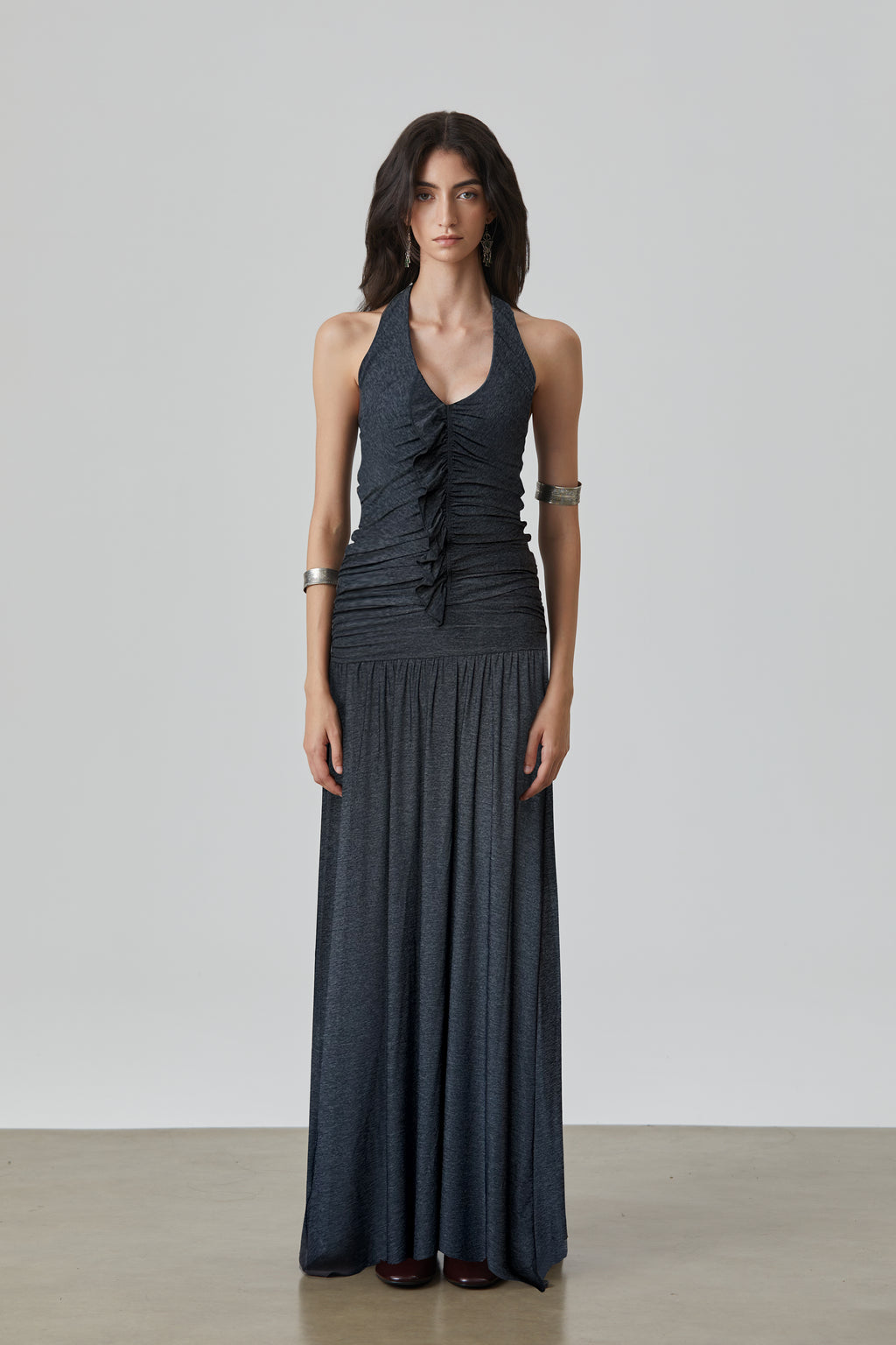 Woman wearing a long dark gray YMH dress against a plain background